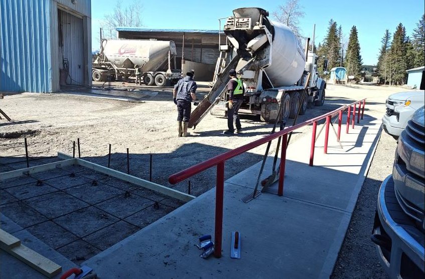 Concrete truck pouring a formed and rebar-reinforced pad on site